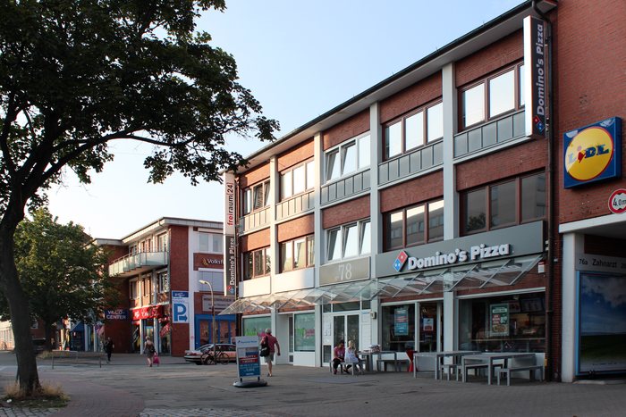 Klinkerhaus Winterhuder Weg 78 mit Ladenflächen im Erdgeschoss und Bäumen davor