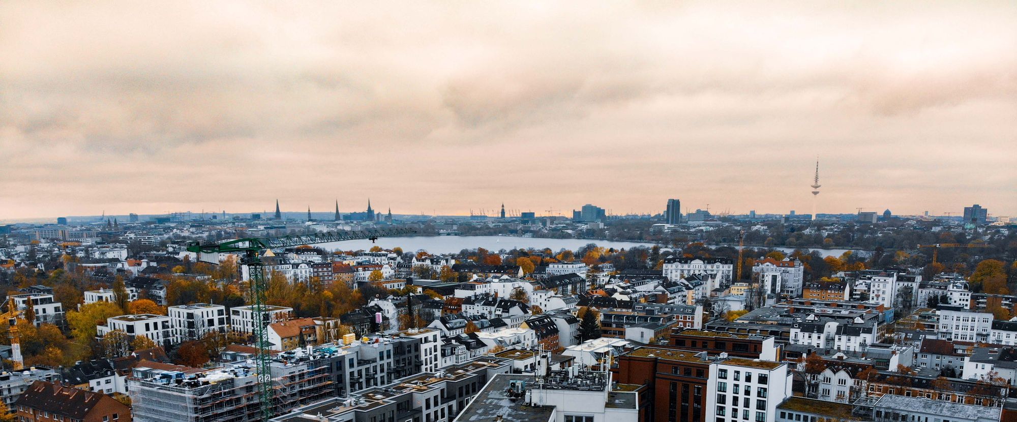 Drohnenblick über Hamburg-Uhlenhorst zur Außenalster, dahinter die Kirchtürme der Innenstadt und der Fernsehturm